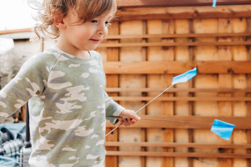 Toddler with a camouflage raglan sweater and little blue flags