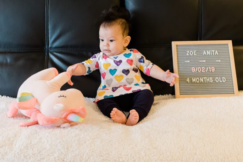 A baby knocking over a stuffed unicorn