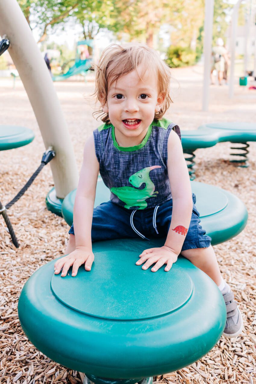 A two year old in a dinosaur tank top